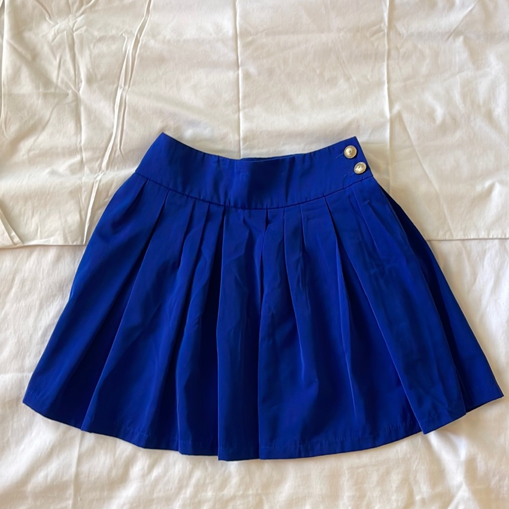 Pleated navy blue skirt. 2 gold buttons & zipper on the side. Only worn 1 time.